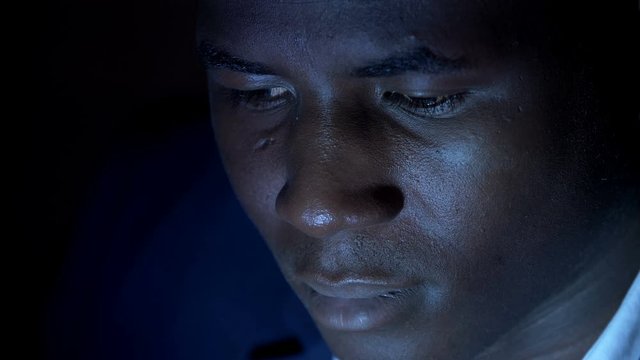 depressed stressed black african man thinking in the dark