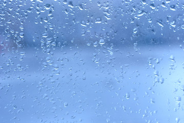 Rain drops on clean blue window glass