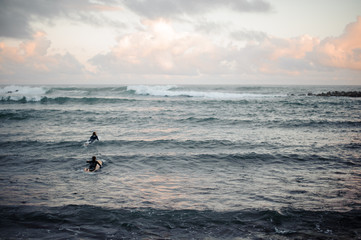 Man and woman swimming on surf boards