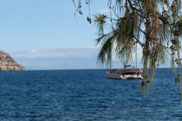 Fototapeta na wymiar Selective focus, view of Puerto de Mogan coastline. Yacht in a background. Gran Canaria. Canary Islands, Spain