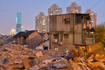 Fototapeta premium Old ruin house with people still living in, modern buildings in background..