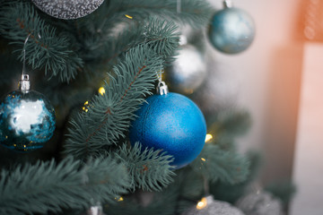 Silver, gold balls on Christmas tree in artificial frost. New Year and Christmas otribut for greeting cards or congratulations. Background fairytale atmosphere, idea decorating house for holiday.