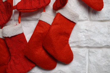 Beautiful background of Christmas decor at living room interior with red knitted gift socks. Cozy New Year atmosphere. Selective focus, close up