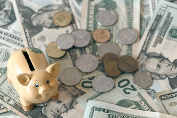 Piggy bank and russian ruble coins, RUB kopeyka on american USD dollar banknotes background