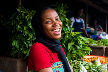 young happy african woman selling in a local market laughing