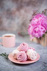 Homemade berry marshmallow in a plate is on the table with a Cup of tea.