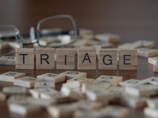 triage the word or concept represented by wooden letter tiles