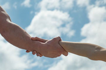 Helping hand. Mutual support and revenue. Friends. Two hands together against the sky. Marriage....