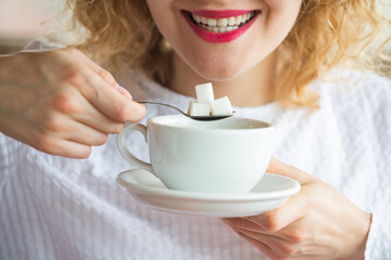 Sugar addiction. Three cubes of sugar in one coffee. Young woman and diet. Dental health. Refined...
