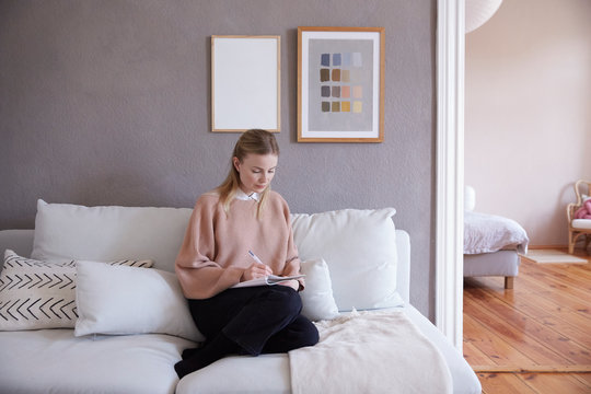 A woman writing on her notebook.