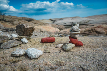 Balancing rocks on a boulder on a sunny cloudy day.