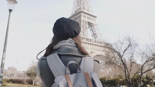 Rear view happy freelance photographer woman taking a picture of Eiffel Tower in Paris on business trip slow motion.