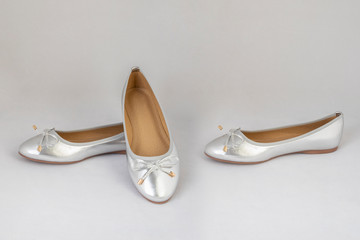 Ladies silver reflective flat shoes on white background