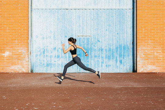 Young runner passing in front of a big blue metal door