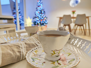 Closeup photo of cups of tee on tray with christmas tree on background