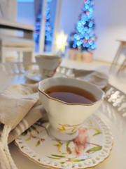 Fototapeta na wymiar Closeup photo of cups of tee on tray with christmas tree on background