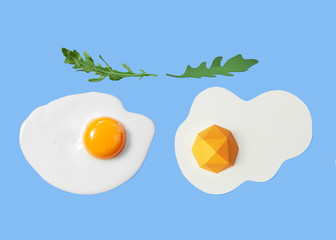 Hand crafted paper egg and natural raw egg and rucola leaves on a blue background with copy space. Healthy food. Flat lay