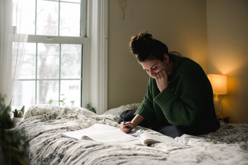 teen studying on her bed