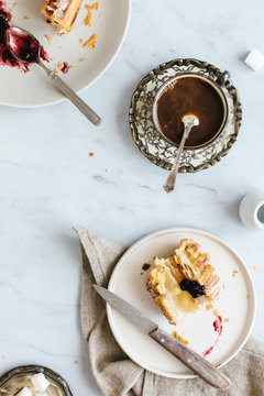 Having breakfast with fruit sweets fro two rolls and coffee