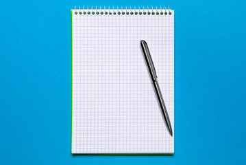 school notebook on a blue background, spiral notepad on a table