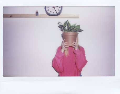 Instant shot of woman covering face with pot