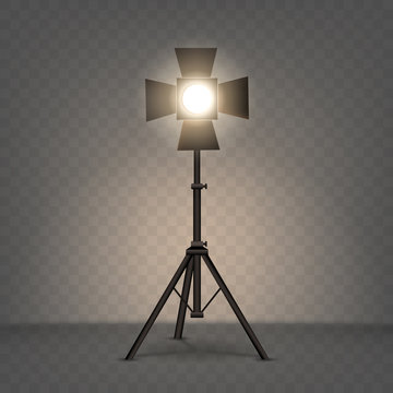 Spotlight realistic vector. Professional photo and video lamp, standing on tripod, stage equipment with warm yellow light on transparent background.