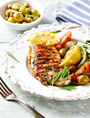Grilled turkey breast with fresh salad and herbs. Broght wooden background. 
