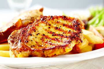 Grilled pork steak with french fries. Close up. 