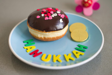 Hanukkah concept with traditional donut, chocolate coins, spinning top.