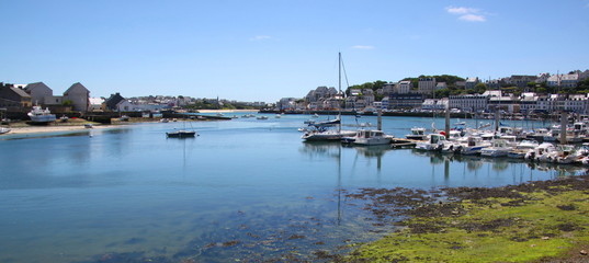 Panoramic Audierne city harbor view with motorboats in the marina and cityscape in the background, Bretagne in France