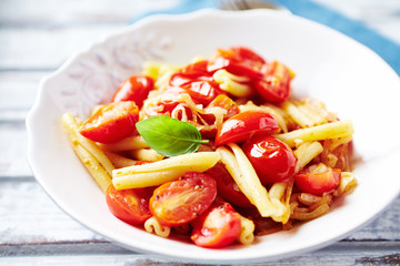 Casarecce pasta with cherry tomatoes and fresh herbs. Close up.