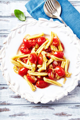 Casarecce pasta with cherry tomatoes and fresh herbs. Top view. 