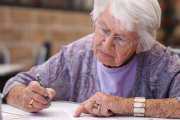 Older woman signing a document