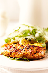 Grilled Chicken Breast with oven baked potatoes and fresh rocket. Bright background. Close up. 
