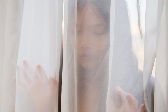 beautiful woman behind a transparent veil