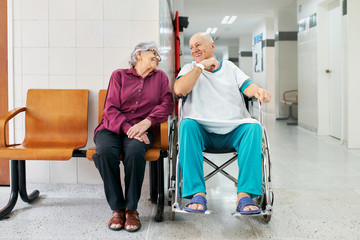 Senior couple waiting in a hospital, smiling