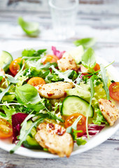 Healthy Salad with Chicken Briest, Cherry Tomatoes, Cucumber, Rocket and fresh Basil. Close up. 