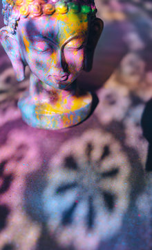 Colorful, vibrant Buddha figurine painted in bright, rich colors