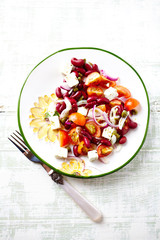 Tasty and easy Salad with Cherry Tomatoes, Feta Cheese, Capers and Kidney Bean. Healthy summer snack. Bright wooden background. Top view. 