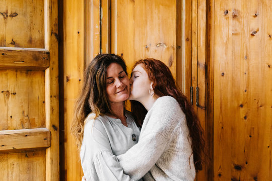 Mother and daughter hugging near door