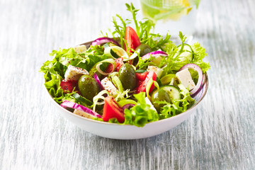 Salad with Green Olives, Tomatoes, Endive, Cucumber and Feta Cheese. Wooden background. 