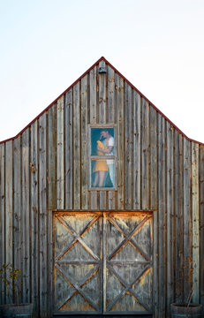 couple at barn window hugging