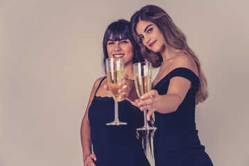 Portrait of two young attractive women with champagne glasses at celebration party