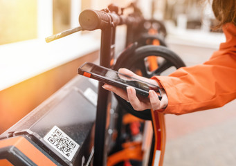 ECO-friendly vehicle.A person holds a smartphone in his hands and reads the code on the information panel. Qr-code. Modern technology