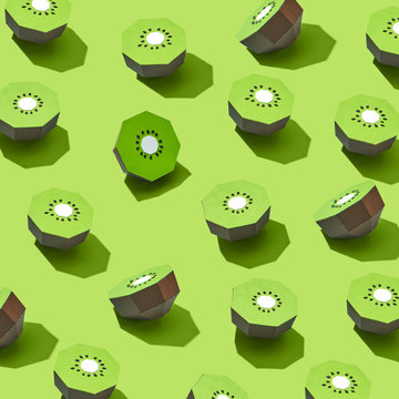 Handcraft kiwi paper halves presented on a green background . Food layout. Flat lay