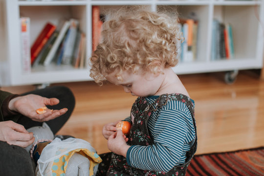 Young Child Peeling Tangerine Fruit