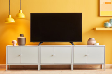 Empty black TV set on white cupboard