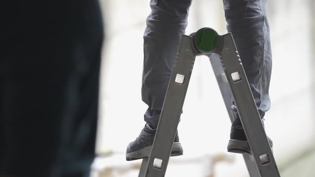 person standing on a working ledder, working environment, building