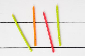 colorful birthday candles on a white wooden background