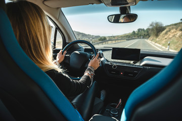 Blonde woman behind the wheel of an electric car
